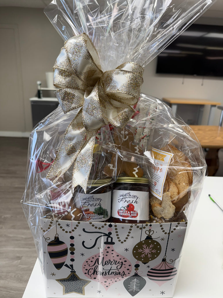 Gift basket with a teddy bear local honey, cookies, and a jars of jam, wrapped in cellophane with a decorative bow.